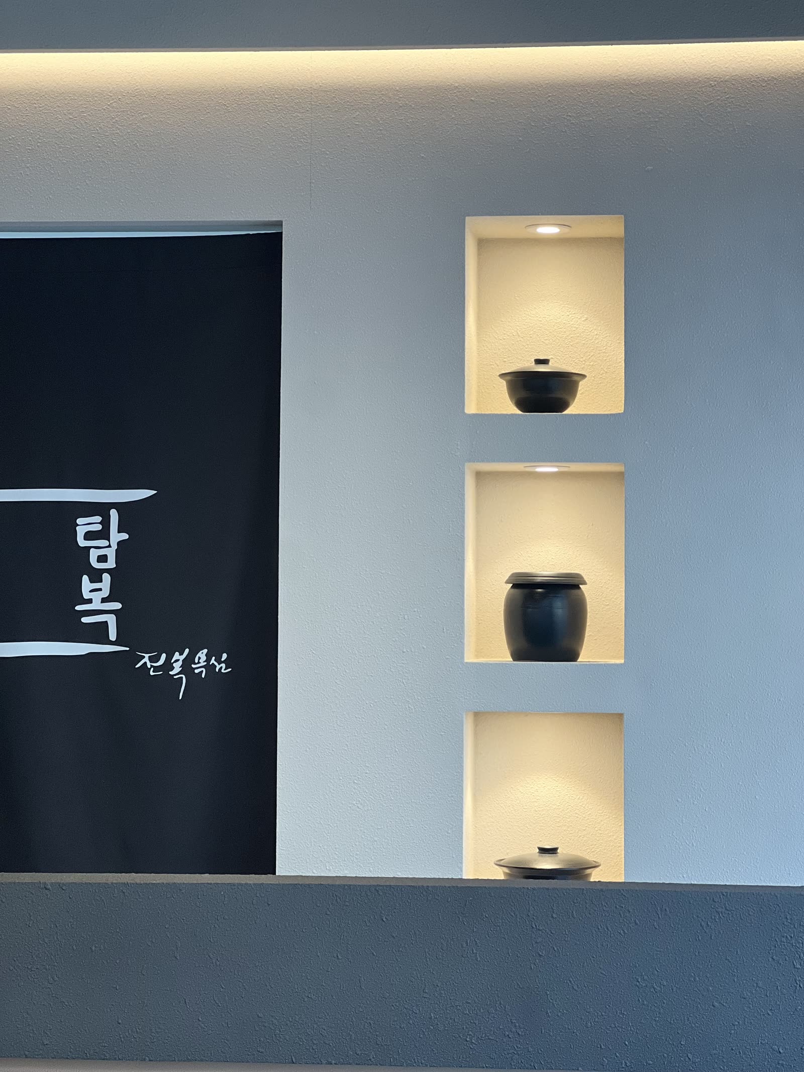 탐복 광교점 내부, 노렌과 도자기 선반이 있는 차분한 자리